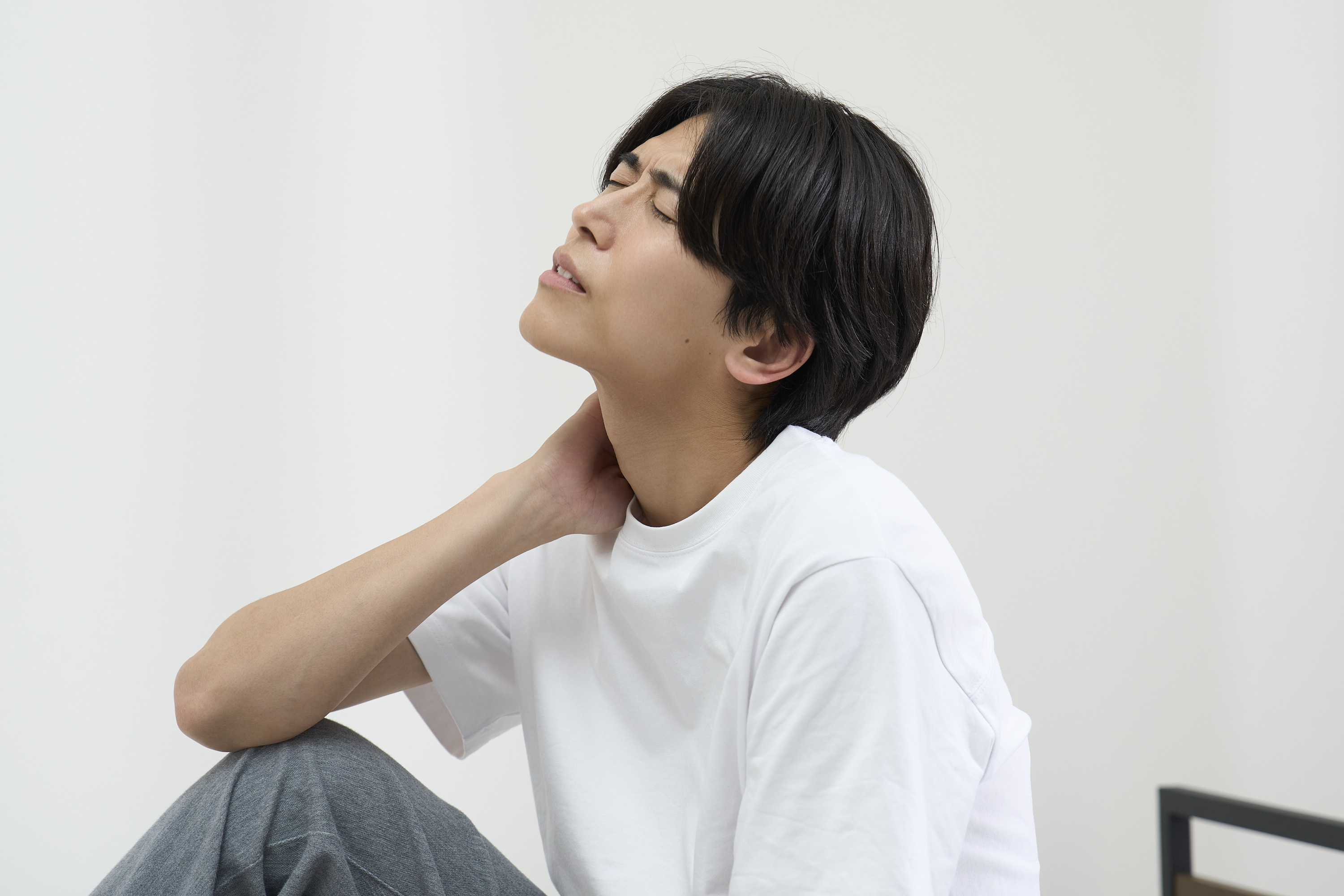首や肩の違和感に悩む女性